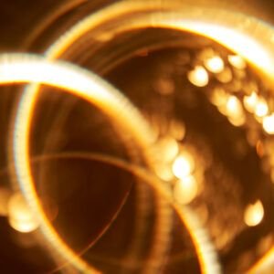 Abstract festive golden background with bright lines of light.